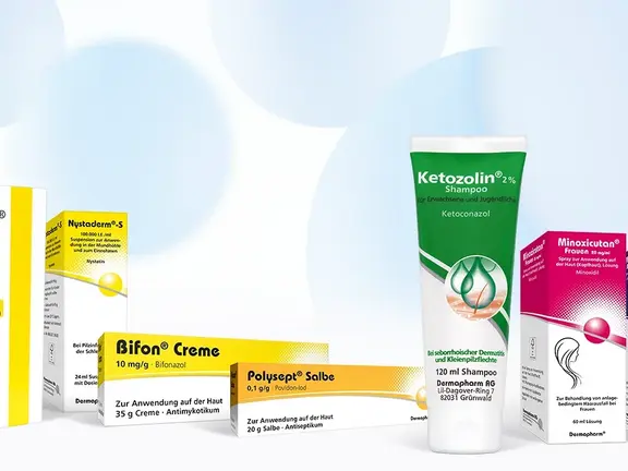 Sechs dermatologische Produktschachteln und Tuben sind aufrecht vor einem abstrakten Hintergrund in Weiß und Blau dargestellt.